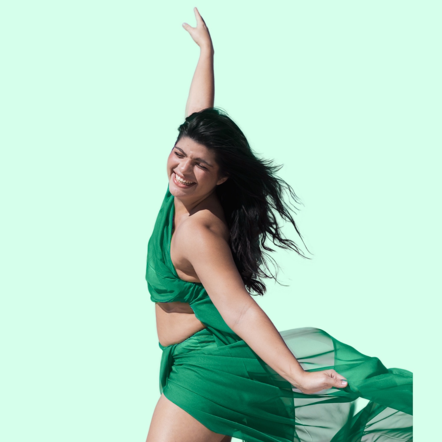 Isabela dançando, sorrindo, com vestido em tons de verde.